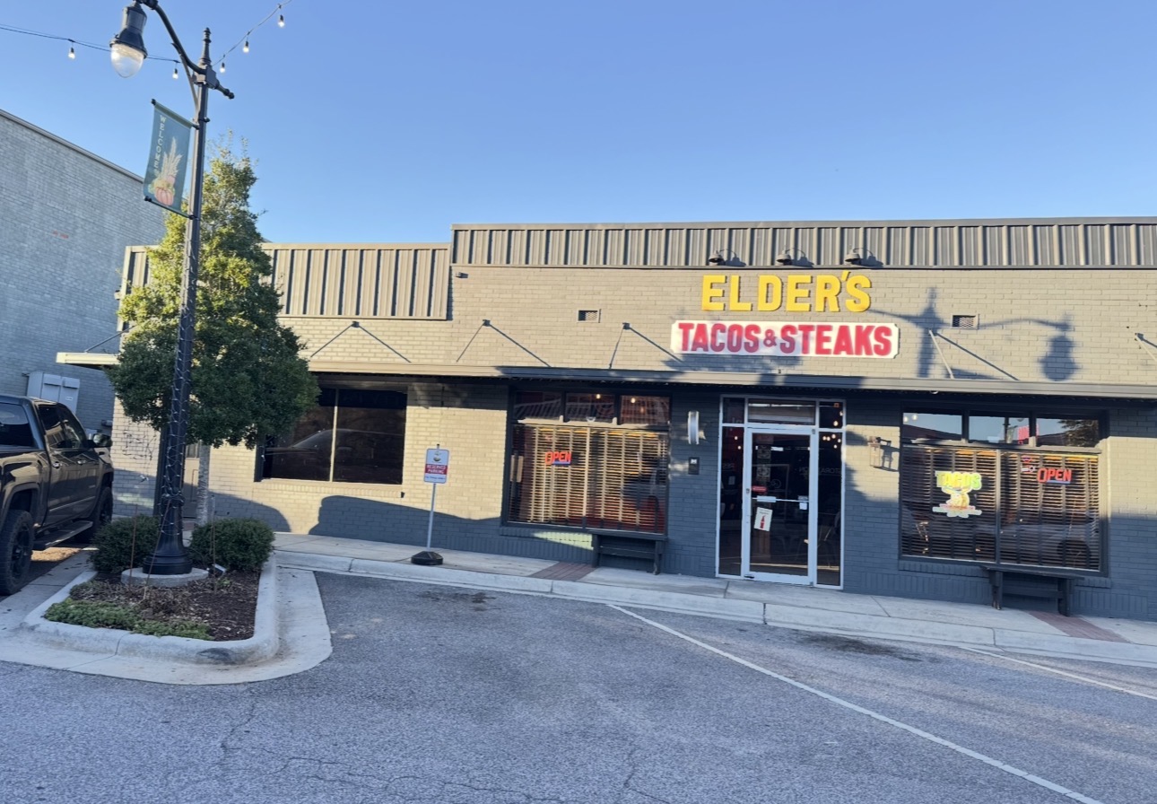 Elder's Tacos & Steaks storefront at night with taco, birria and burrito banners out front