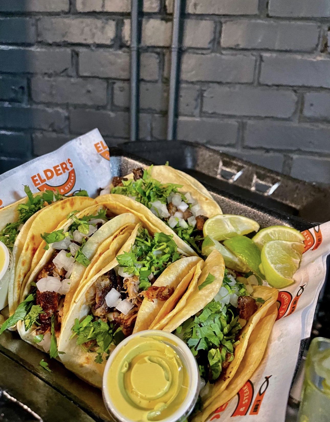 Street tacos on corn tortillas with cilantro, onion, lime and green salsa