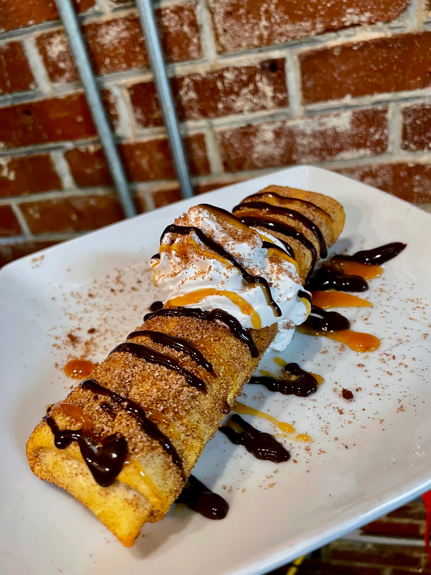 Fried cheesecake with whipped cream, chocolate and caramel drizzle