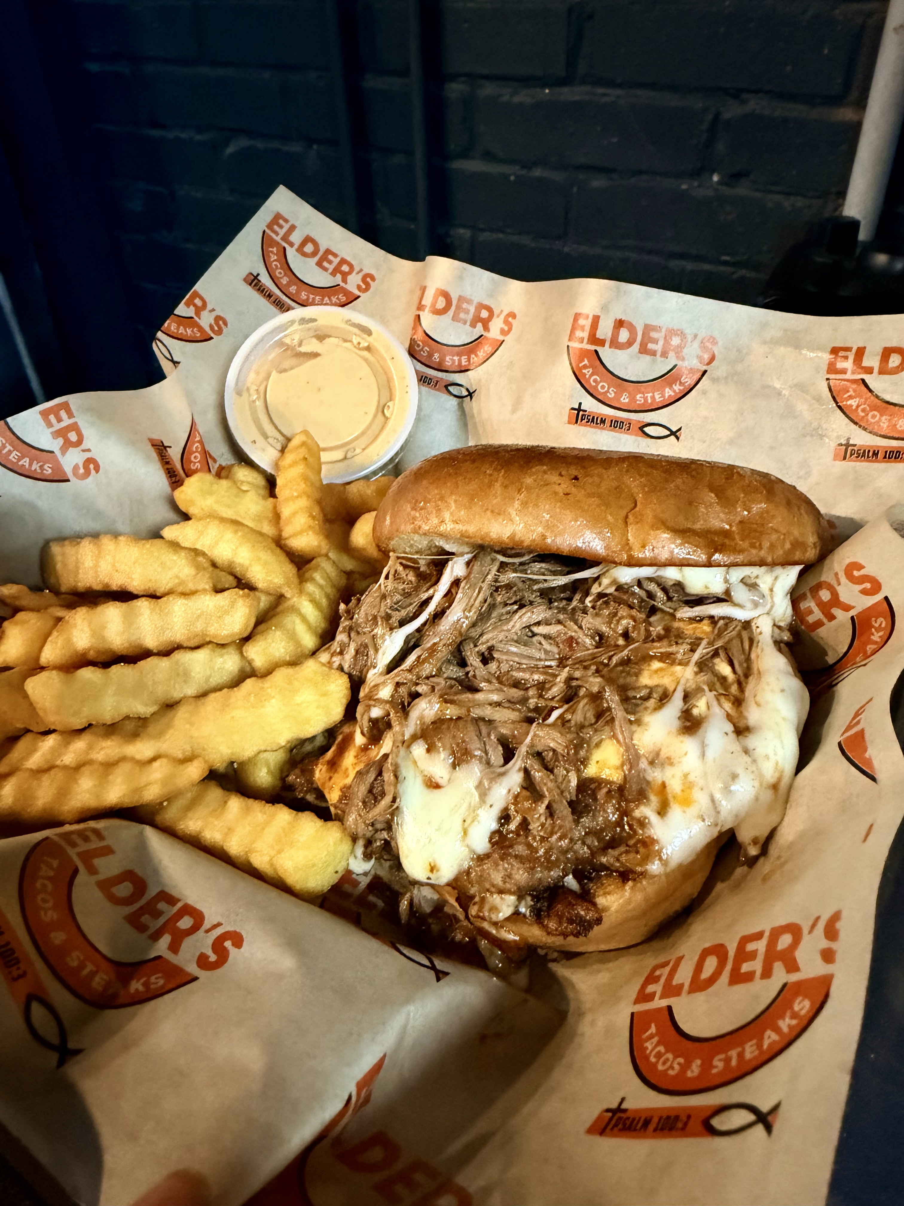 Pulled pork sandwich with melted cheese and crinkle-cut fries
