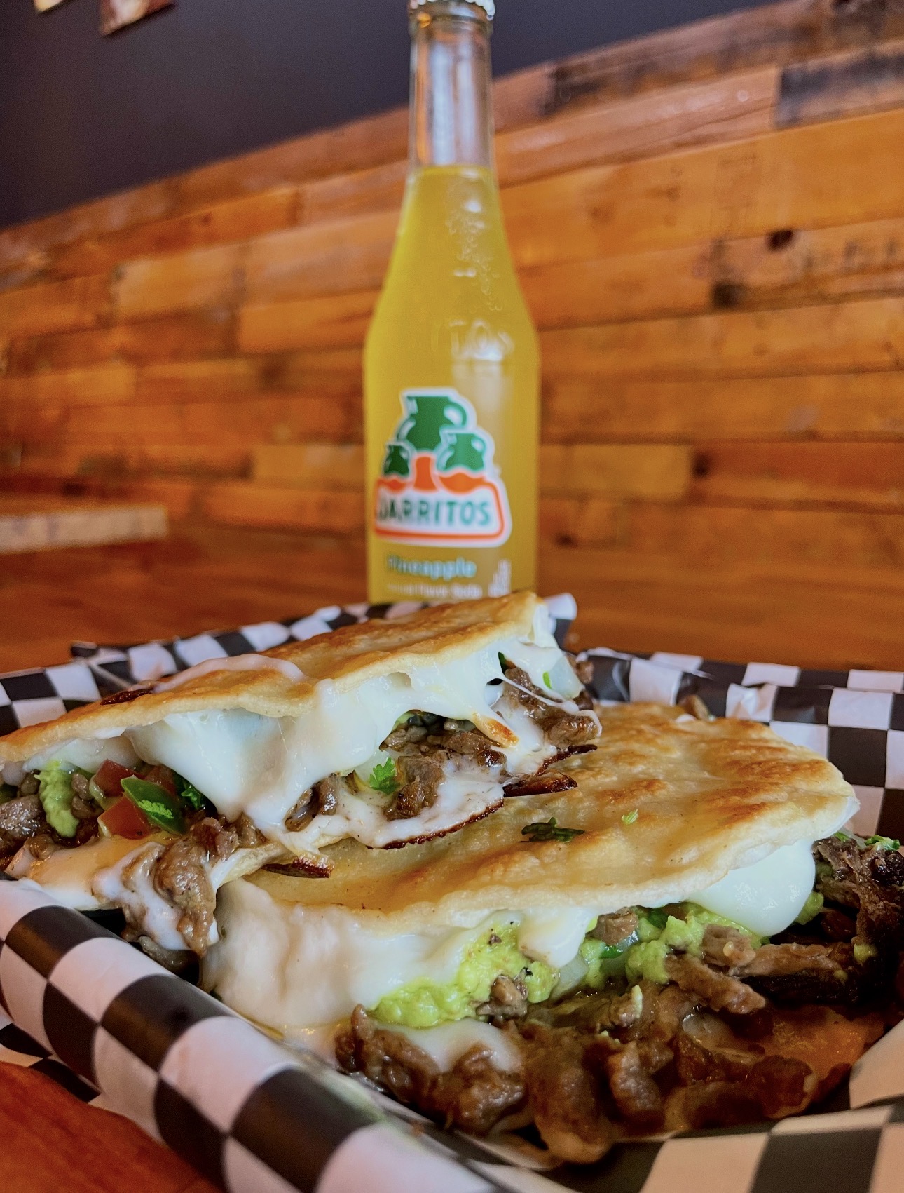Steak quesadilla with guacamole served with a pineapple Jarritos