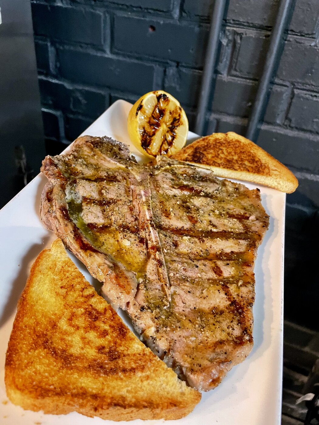 Grilled T-bone steak with charred lemon and Texas toast